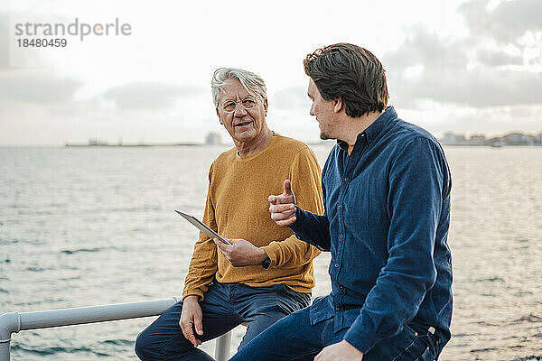 Vater und Sohn diskutieren vor dem Meer