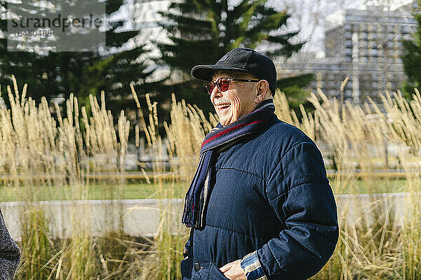 Happy senior man wearing jacket at park