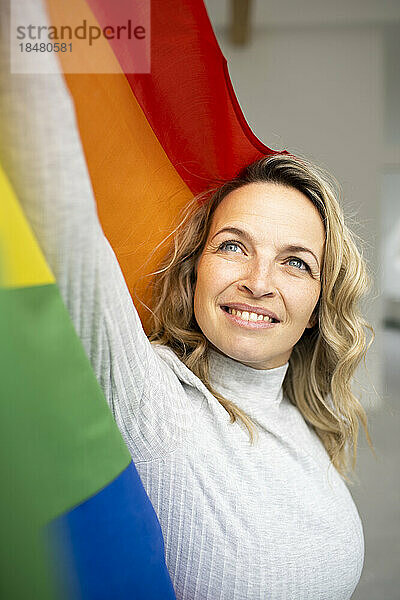 Lächelnde reife Frau mit bunter Flagge