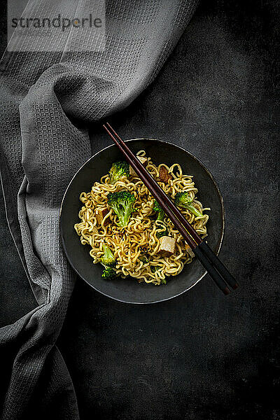 Studio shot of plate of ready-to-eat vegan noodles with broccoli  tofu and soy sauce