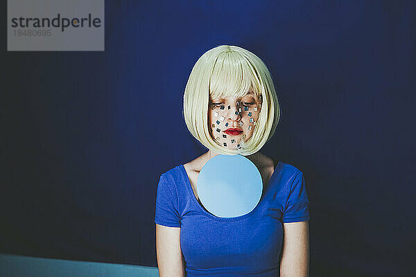 Blonde Frau mit blauem Kreis vor farbigem Hintergrund