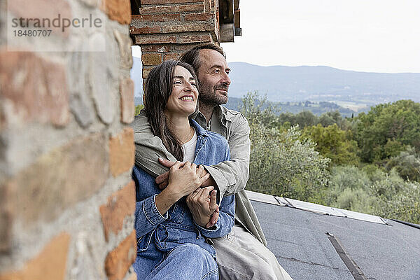 Lächelnder Mann und Frau sitzen auf dem Dach