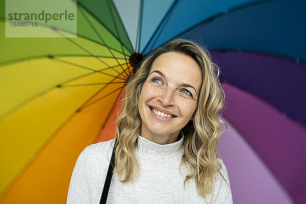 Glücklicher Frauentag  der mit mehrfarbigem Regenschirm träumt
