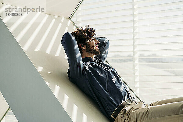 Happy businessman relaxing on alcove window seat