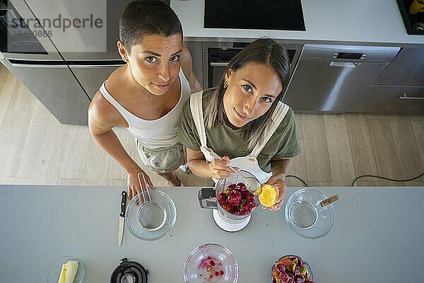 Junge Frau bereitet mit ihrer Freundin in der heimischen Küche Feigenkaktussaft zu