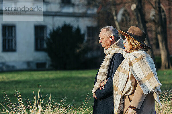 Älteres Paar in warmer Kleidung geht im Park spazieren