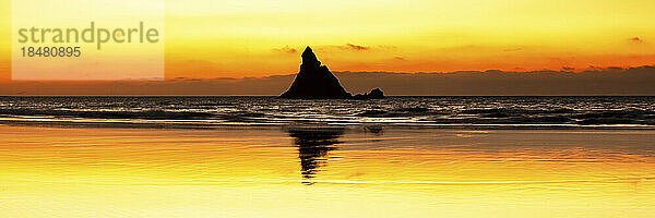 Silhouette Church Rock and tranquil beach at sunset  Pembrokeshire  Wales