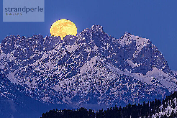 Österreich  Tirol  Gelber Mond geht in der Abenddämmerung über dem Wiedersberger Horn auf