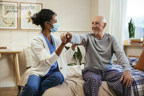 Physiotherapeut untersucht älteren Mann zu Hause