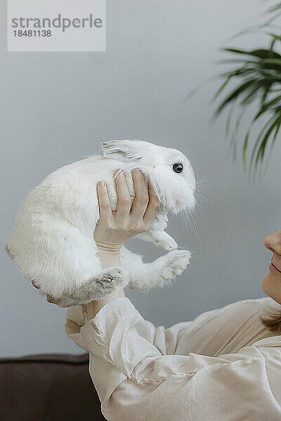 Woman holding baby rabbit at home