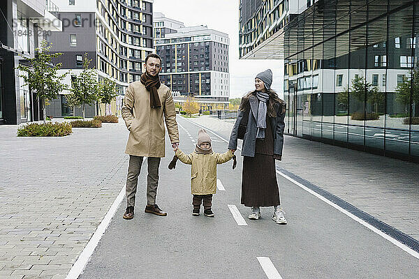 Mann und Frau stehen mit Sohn auf der Straße