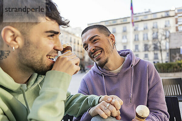 Glücklicher schwuler Mann  der Spaß mit seinem Freund im Straßencafé hat
