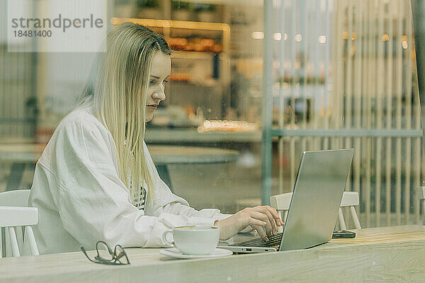 Freiberufler arbeitet am Laptop im Café