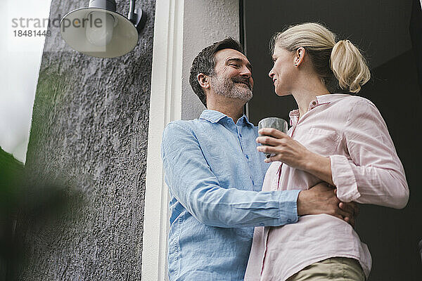 Lächelndes älteres Paar  das vor der Tür miteinander redet