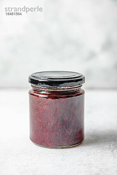 Homemade strawberry jam in jar on table
