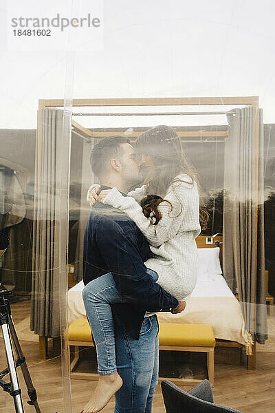 Romantic couple kissing inside dome hotel