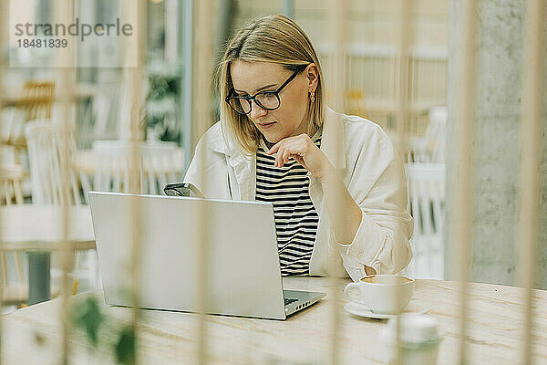 Geschäftsfrau arbeitet am Laptop am Tisch im Café