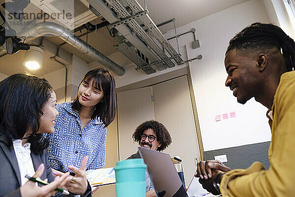 Businesswoman discussing with colleagues in meeting at workplace