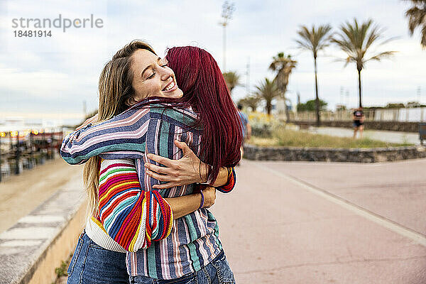 Freunde umarmen sich an der Promenade