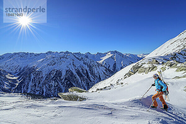 Austria  Tyrol  Sun shining over female skier in Zillertal Alps