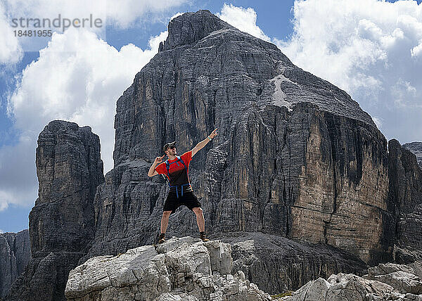 Mann mit erhobenem Arm steht am Cima Pisciadu  Dolomiten  Italien