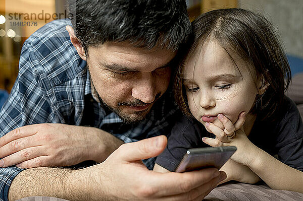 Vater teilt Smartphone mit Sohn zu Hause
