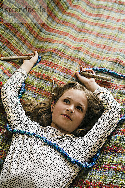 Thoughtful girl with jump rope lying on bed at home