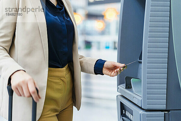 Hand einer Geschäftsfrau  die Kreditkarte am Geldautomaten verwendet