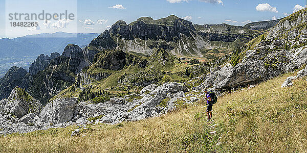 Ältere Frau mit Rucksack steht vor dem Berg in den Dolomiten  Italien