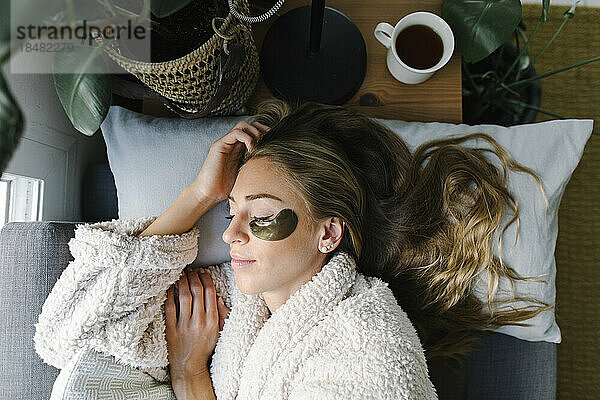 Frau mit Augenklappe schläft zu Hause im Bett