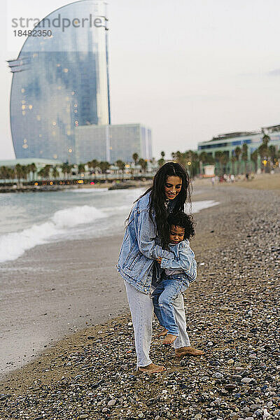 Mutter holt Sohn am Strand ab