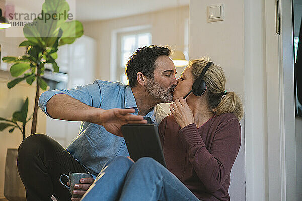 Affectionate freelancers kissing each other at home office