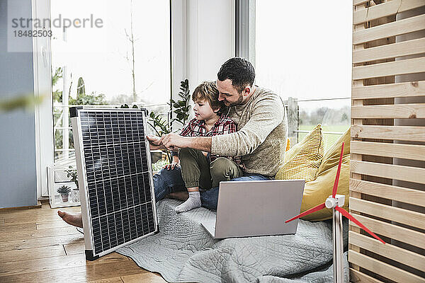 Vater und Sohn schauen auf Solarpanel