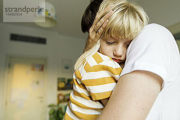 Tochter schläft zu Hause im Arm des Vaters
