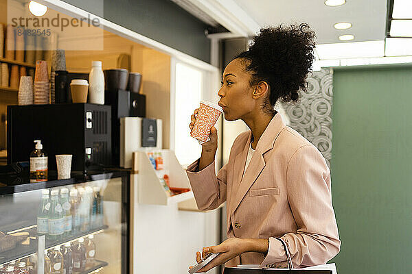 Junge Geschäftsfrau trinkt Kaffee im Café