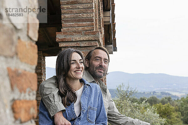 Glückliche Frau mit Mann sitzt auf dem Dach