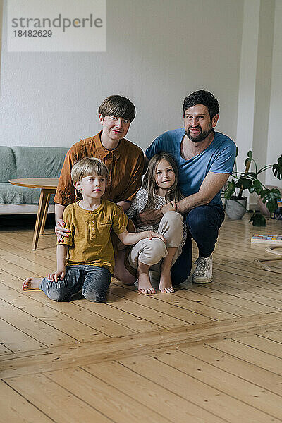Lächelnde Eltern und Kinder im heimischen Wohnzimmer