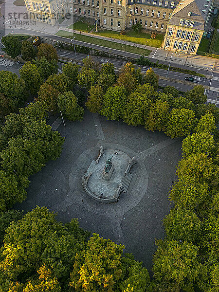 Drone view of King Karl's memorial statue amidst trees  Stuttgart  Germany