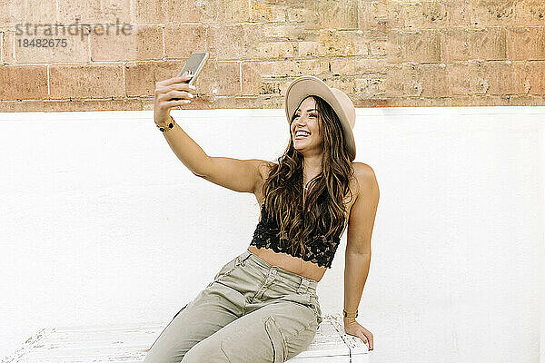 Happy woman taking selfie through smart phone