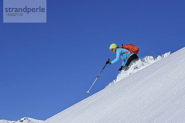 Austria  Tyrol  Female skier sliding down snowcapped slope in Kitzbuhel Alps