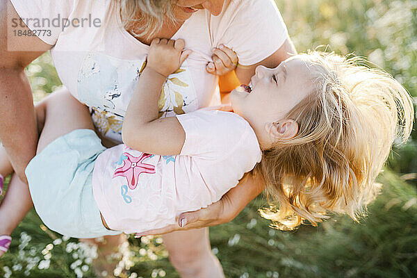 Happy girl with mother in summer field