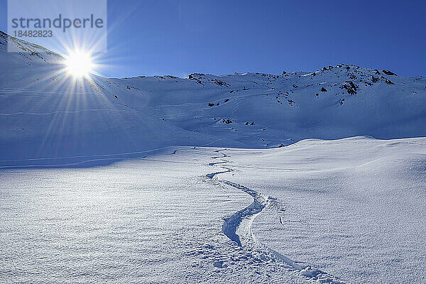 Österreich  Tirol  Sonne scheint über kurvenreicher Strecke im Schnee
