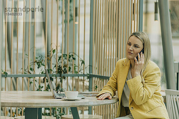 Geschäftsfrau telefoniert im Café