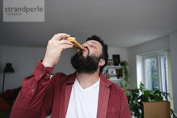 Reifer Mann isst zu Hause Pizza