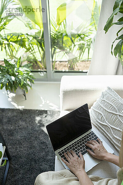 Freiberufler arbeitet am Laptop im Wohnzimmer