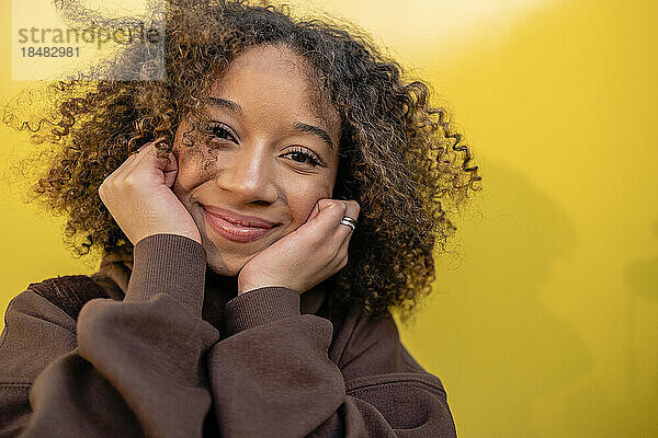 Lächelnde junge Frau mit lockigem braunem Haar