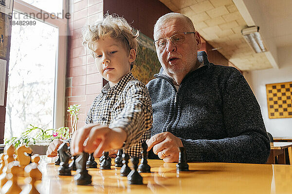 Sohn spielt Schach mit Großvater im Club