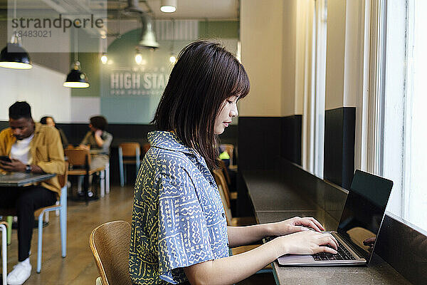 Geschäftsfrau arbeitet am Laptop und sitzt am Arbeitsplatz