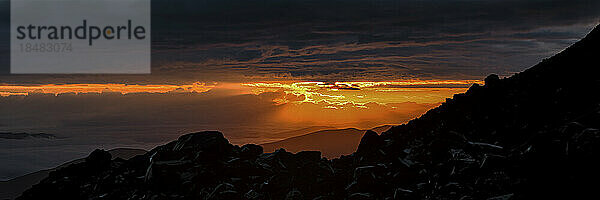 Dramatischer Himmel über Silhouettenbergen bei Sonnenuntergang  Elbrus  Kaukasus