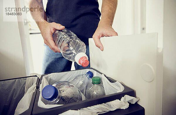 Junger Mann recycelt Plastikflaschen zu Hause